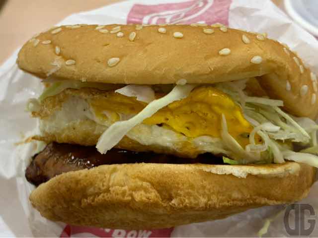 バンズに挟まれている具材が上から、キャベツ、目玉焼き、そしてソースたっぷりのお好み焼き